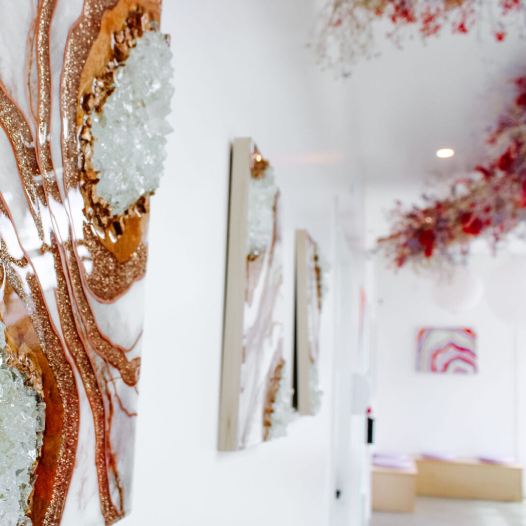 A white hallway with gem stone artwork. Brand photography for the Collective Suites.