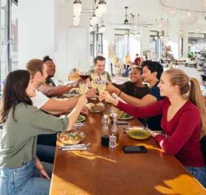 Small business marketing in Kamloops example photo shows a group of friends toasting with white wine in restaurant